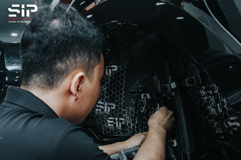 Kỹ thuật viên thi công dán cách âm SIP cho hốc bánh ngoài 