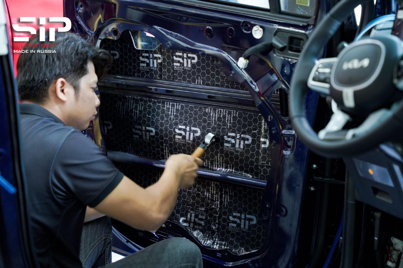 Kỹ thuật viên thi công dán cách âm cửa xe hơi 