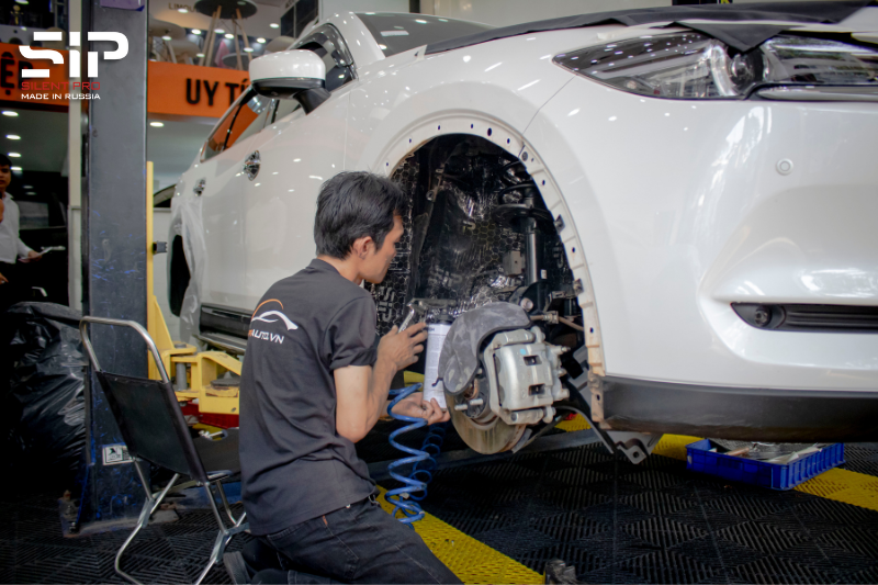 Kỹ thuật viên thi công xịt sơn phủ gầm xe